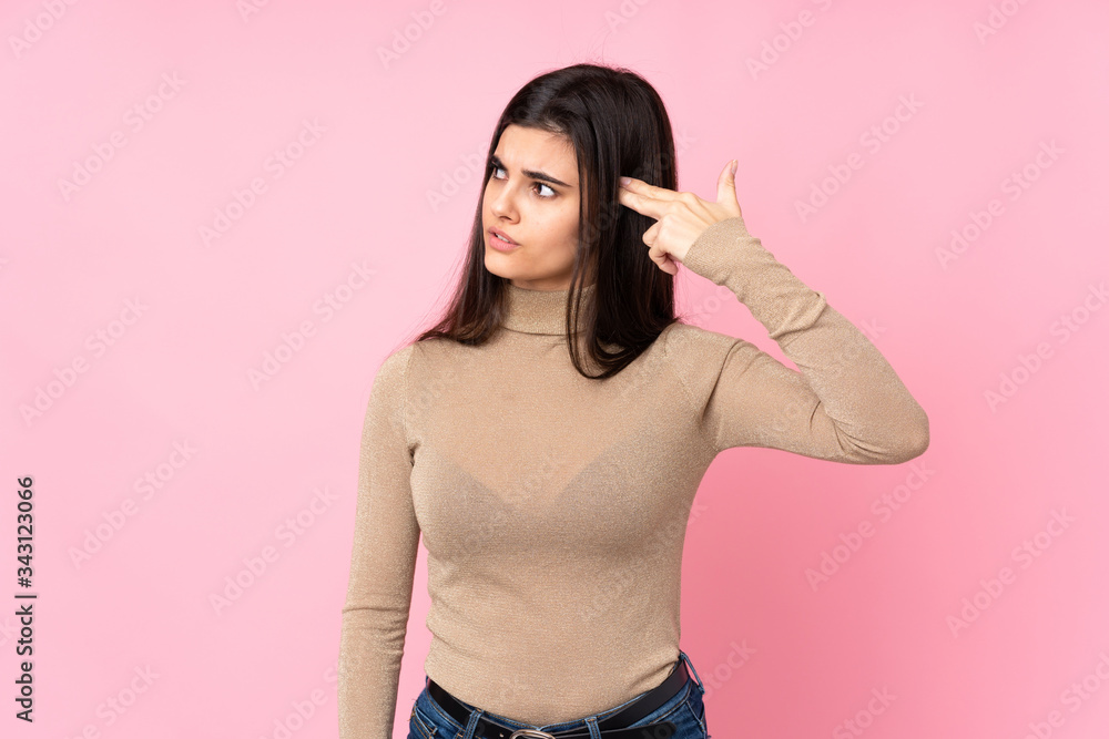 Young woman over isolated pink background with problems making suicide gesture Young woman over isolated pink background with problems making suicide gesture