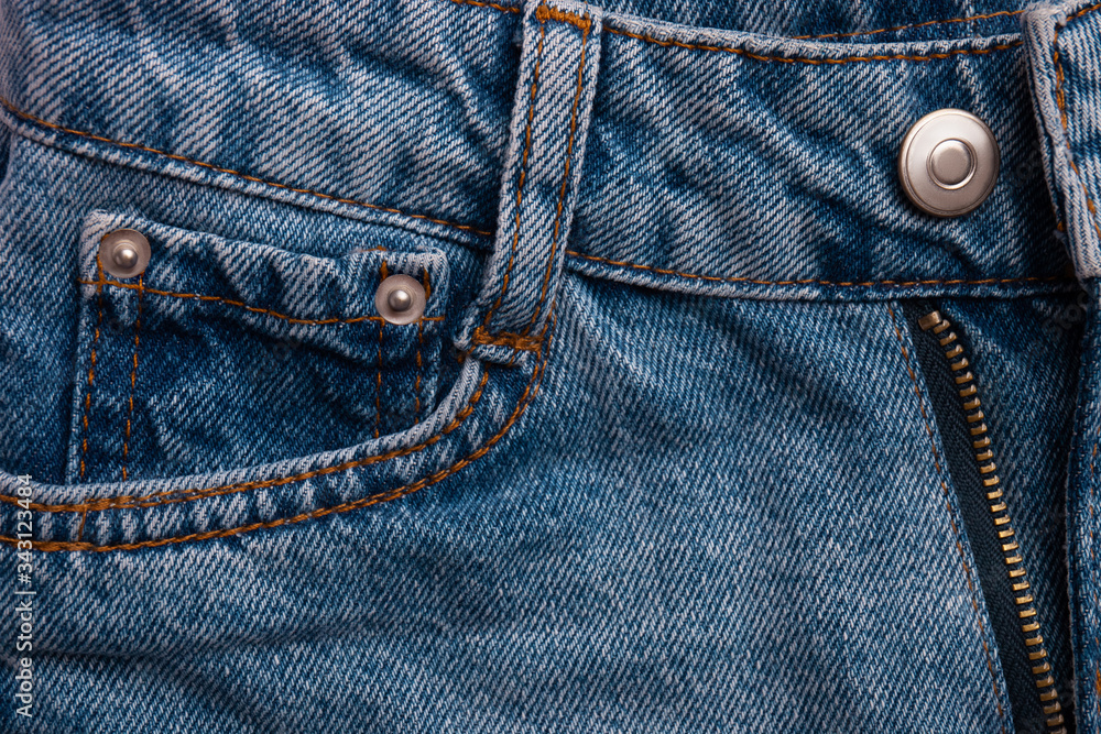 Blue jeans with pocket as background. Macro view of new jeans pants with details. Top view Blue jeans with pocket as background. Macro view of new jeans pants with details. Top view
