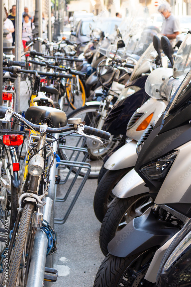 intertwining of bicycles and scooters parked in the city intertwining of bicycles and scooters parked in the city