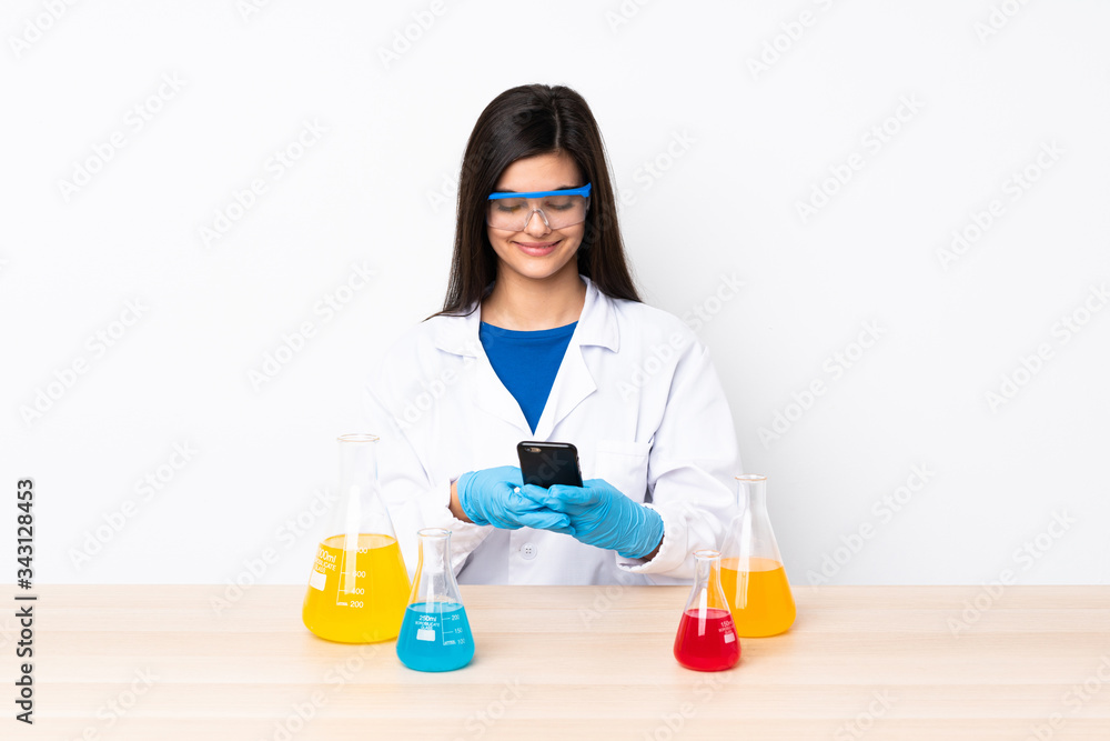 Young scientific woman in a table sending a message with the mobile Young scientific woman in a table sending a message with the mobile