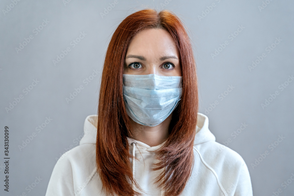 Portrait of sexy woman with red hair in medical mask close-up in studio. Girl in medical mask against viruses and infections. Coronavirus 2019-ncov covid-19 concept. Portrait of sexy woman with red hair in medical mask close-up in studio. Girl in medical mask against viruses and infections. Coronavirus 2019-ncov covid-19 concept.
