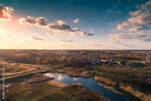 Aerial view of countryside and brook in evening at sunset light. Beautiful rural nature landscape