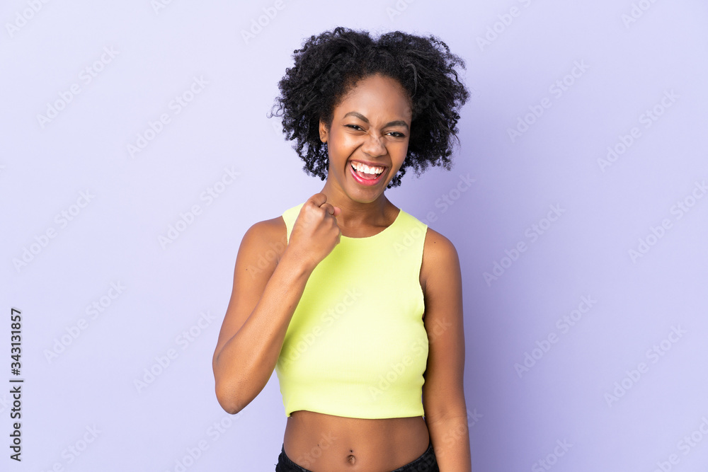 Young African American woman isolated on purple background celebrating a victory