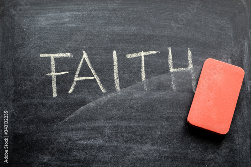 Valokuva erasing faith, hand written word on blackboard being erased concept
