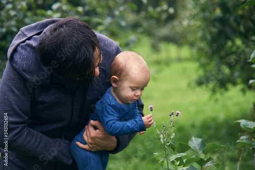Baby picking wild flowers in garden