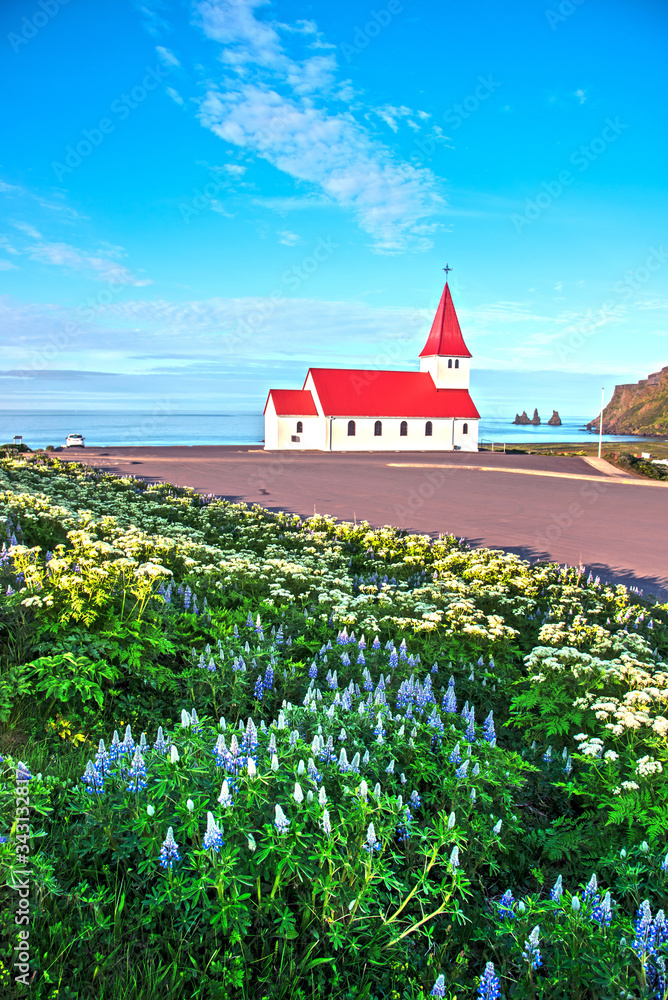 The famous Vik church (Vikurkirkja) on the background of the sea and the fingers of the troll in Iceland. place of pilgrimage. Impressive landscape. Exotic countries. Amazing places.