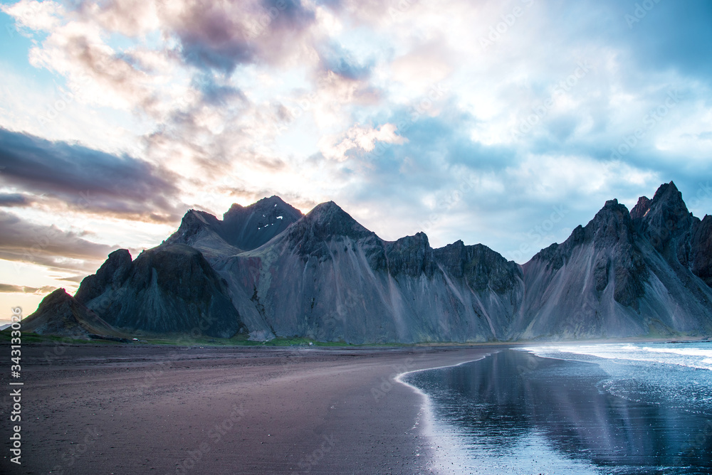 Scenic landscape with most breathtaking mountains Vestrahorn on the Stokksnes peninsula with the waves of the bay at sunset in Iceland. Exotic countries. Amazing places.