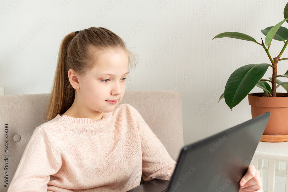 School girl studying at home with laptop notebook and listens to an online lesson. Home education, quarantine concept School girl studying at home with laptop notebook and listens to an online lesson. Home education, quarantine concept