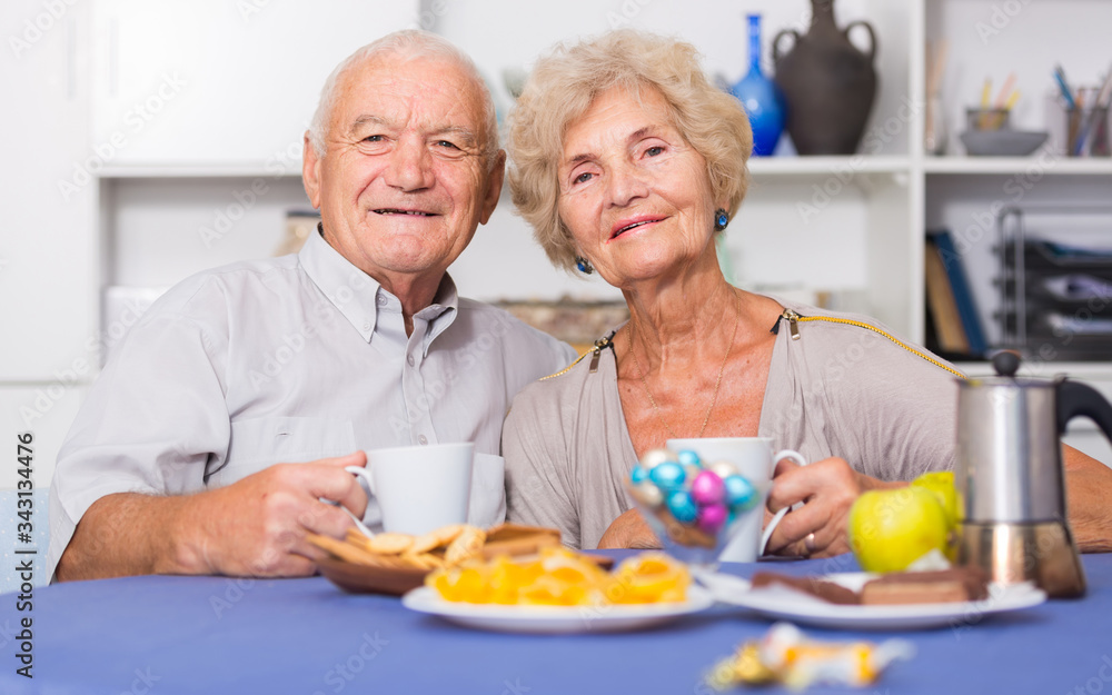 Happy mature couple drinking tea in kitchen
