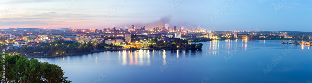 Panorama of the night city and metallurgical plant from a height. White nights in the city