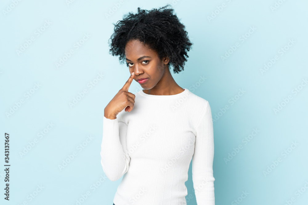 Young African American woman isolated on blue background showing something Young African American woman isolated on blue background showing something