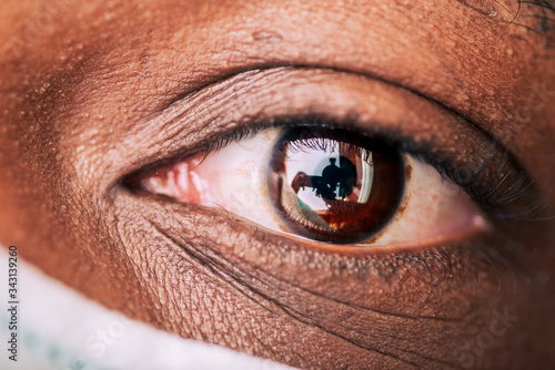 close up of aftican american brown eye wearing a protective surgical mask photo