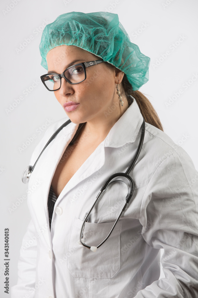 Medico donna con cuffietta per i capelli , occhiali , camice e stetoscopio al collo , isolata su sfondo bianco Medico donna con cuffietta per i capelli , occhiali , camice e stetoscopio al collo , isolata su sfondo bianco
