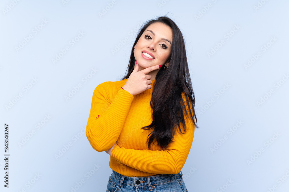 Young Colombian girl over isolated blue background smiling Young Colombian girl over isolated blue background smiling
