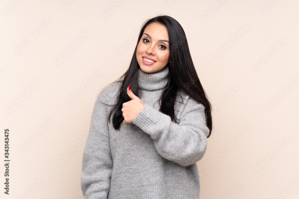 Young Colombian girl over isolated background giving a thumbs up gesture Young Colombian girl over isolated background giving a thumbs up gesture