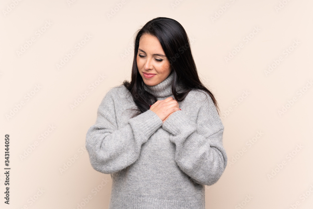 Young Colombian girl over isolated background having a pain in the heart Young Colombian girl over isolated background having a pain in the heart
