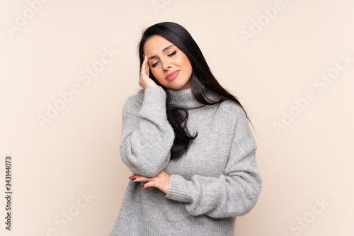 Young Colombian girl over isolated background with headache © luismolinero