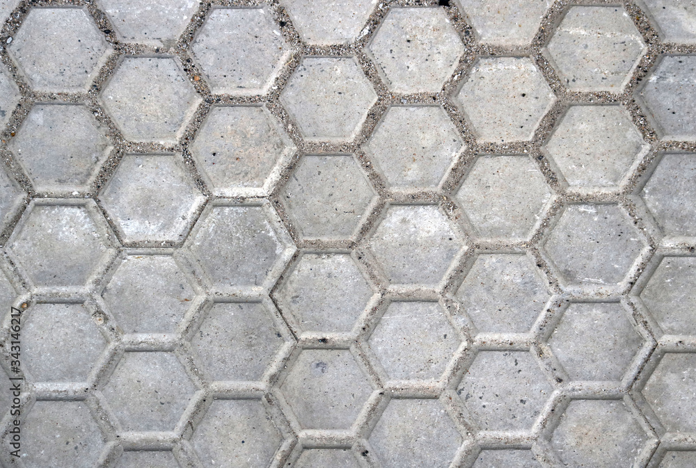 rough gray slabs or tiles with hexagonal shape of dirty street floor of a road - urban background