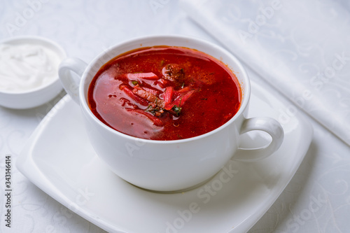 Borscht with sour cream on white plate