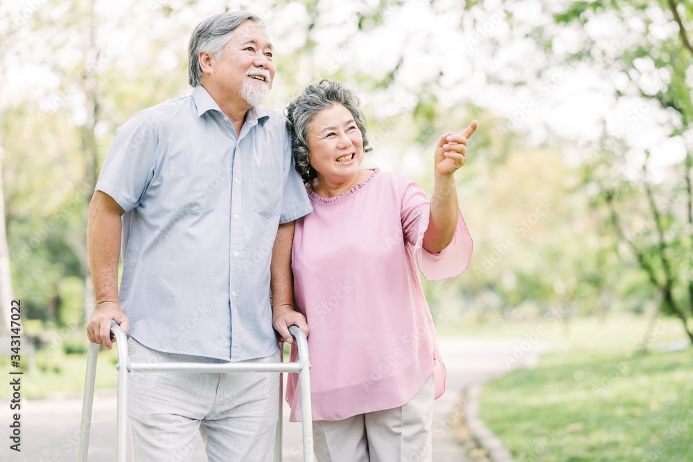 Portrait of happy loving senior Asian couple walking with walker in the park Portrait of happy loving senior Asian couple walking with walker in the park