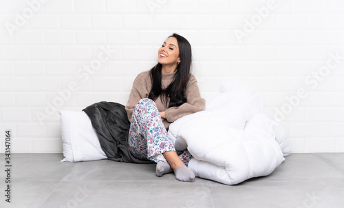 Young Colombian girl in pajamas at indoors happy and smiling