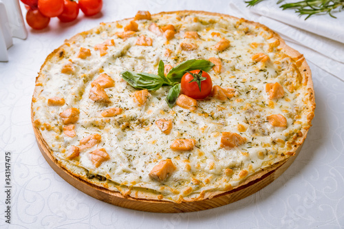 Pizza with salmon and Philadelphia cheese on white table