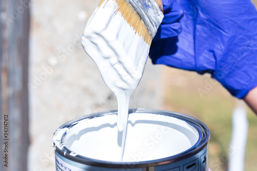 man paints with white paint