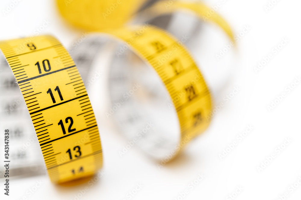 Yellow measuring tape on white background. Measurement of length and circumference. Lose weight and get fat. Yellow measuring tape on white background. Measurement of length and circumference. Lose weight and get fat.
