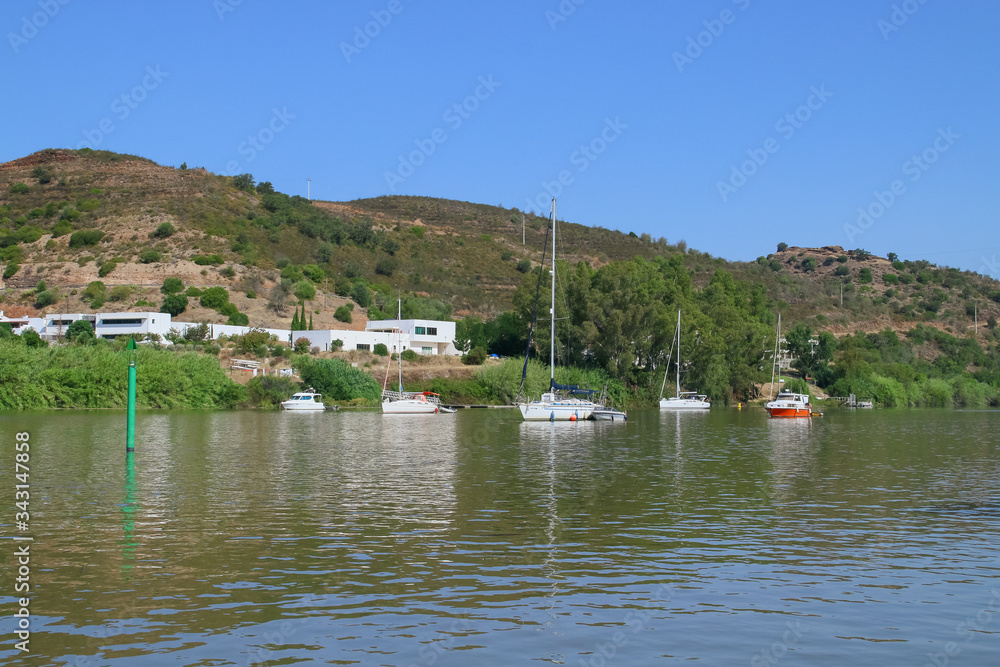 Barcos fondeados en el río Guadiana en el tramo fronterizo entre España y Portugal. Al fondo se observa la orilla portuguesa perteneciente a la pequeña localidad de Alcoutim.