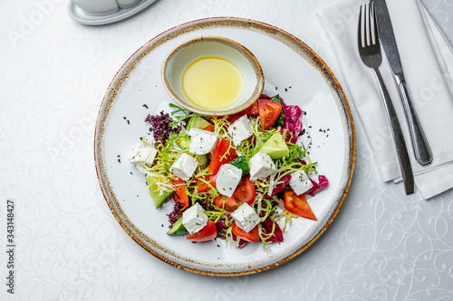 Greek salad with feta on white table