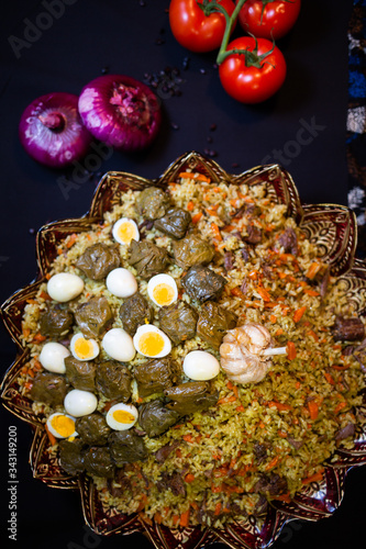Traditional georgian dolma in grape leaves on black table with female hand