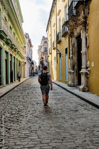 Man with a backpack on walking away from the camera in Old Havana. © Nikolaj