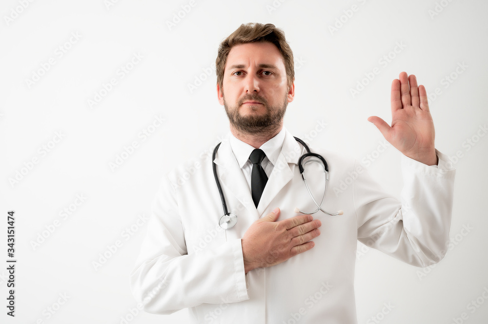 Male doctor with stethoscope in medical uniform showing oath Male doctor with stethoscope in medical uniform showing oath