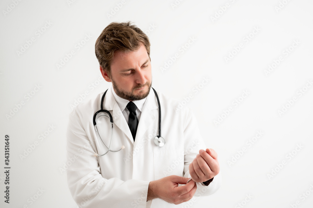Male doctor with stethoscope in medical uniform arranges his uniform Male doctor with stethoscope in medical uniform arranges his uniform
