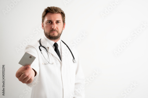 Male doctor with stethoscope in medical uniform give the card