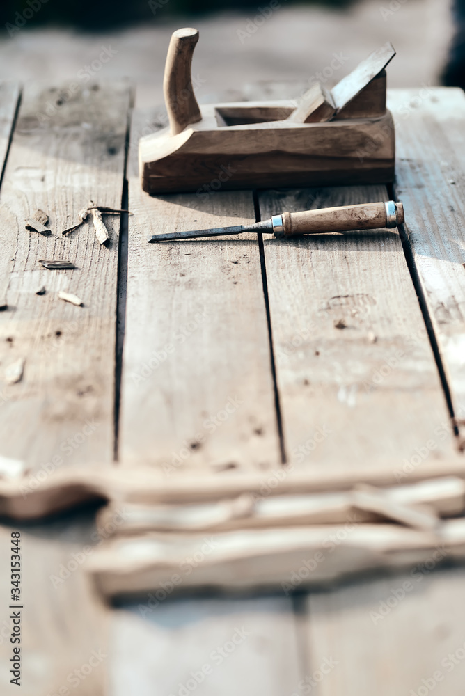 wooden background. On the village table lie dotches, sawdust, and on the background of the bit and jointer plane. vertical picture. Wood thread tool. solar lighting