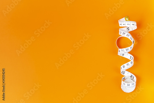 Orange background with centimeter. Diet and healthe care concept. Copy space. Place for text and design.