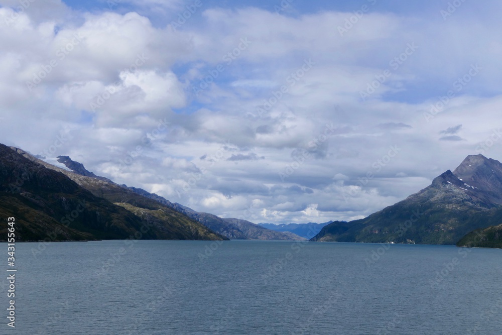 Snowy mountains in chilean fjord with blue sky and clouds, Strait of Magellan