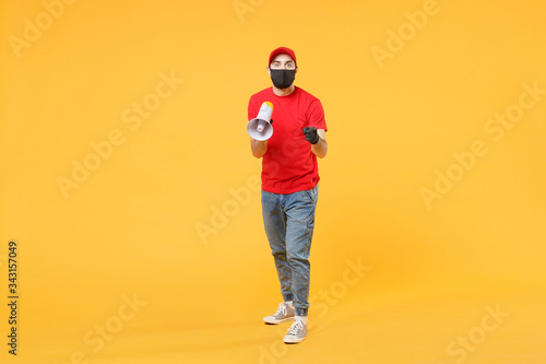 Delivery man in red cap blank t-shirt uniform mask gloves isolated on yellow background studio Guy fun employee working courier scream in megaphone Service pandemic coronavirus virus 2019-ncov concept
