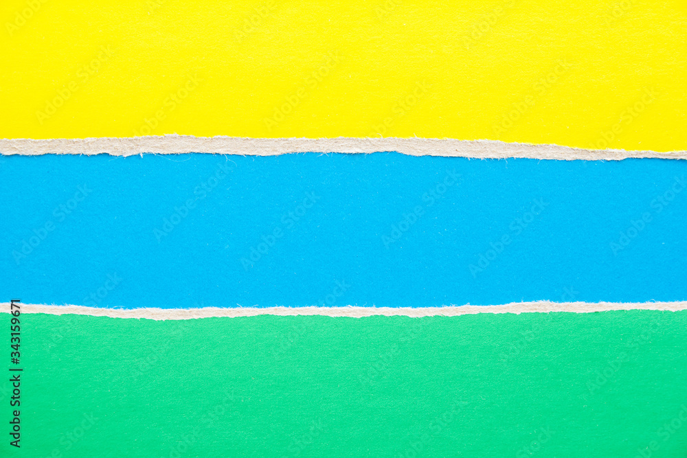 Blue, green and yellow torn cardboard paper background with copy space for text message.