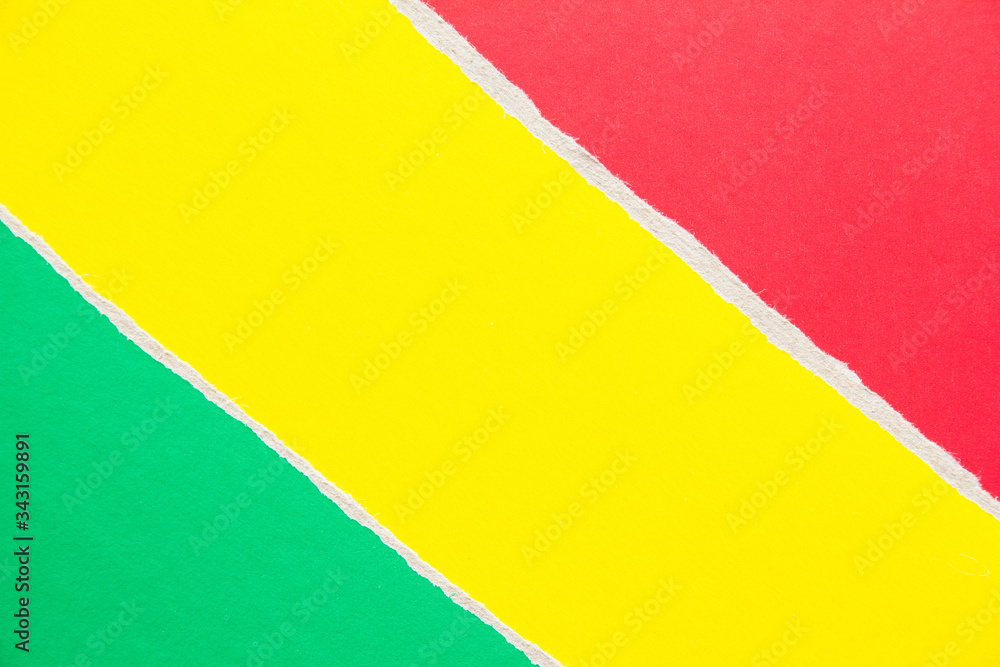 Fototapeta premium Yellow, green and red torn sheet of cardboard paper with diagonal border texture background. Copy space for text message.