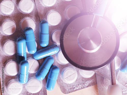 Blue capsules and a stethoscope so close, top view