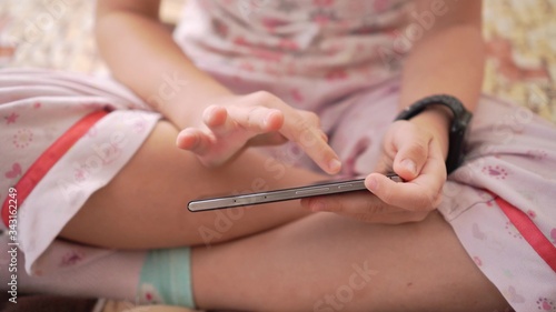 Smartphone in the hands of a child, close-up. Play mobile app.