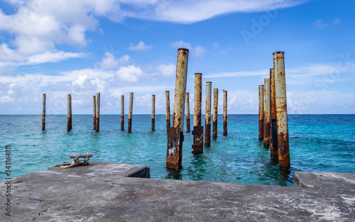 Rusty poles in ruins of old pier in beautiful blue water  © dalomo84