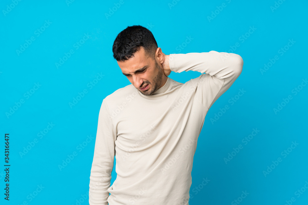 Young man over isolated blue background with neckache Young man over isolated blue background with neckache