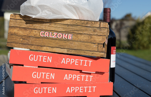 stack of cardboard box for pizza with german inscription for enjoy your meal