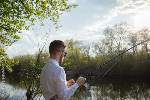 A man fishing in a business suit, in a white shirt and tie © Greenart