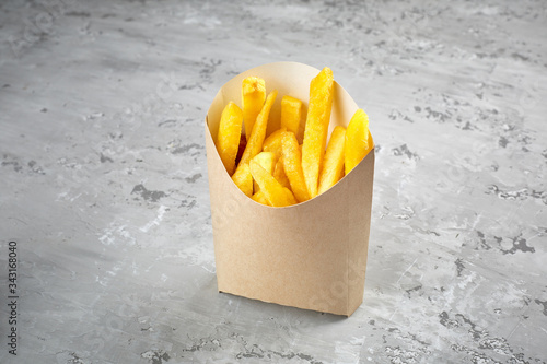 Packing of fried fries on a concrete table background.