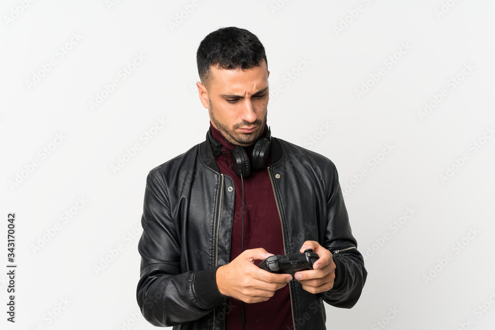 Young man over isolated white background playing at videogames Young man over isolated white background playing at videogames