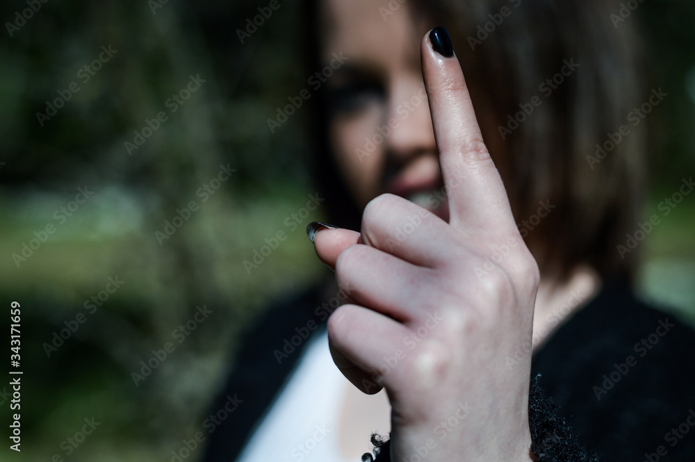 Young woman doing number one sign with the hand. Happy girl giving satisfied and supportive hand gesture. Focus on the hand.
